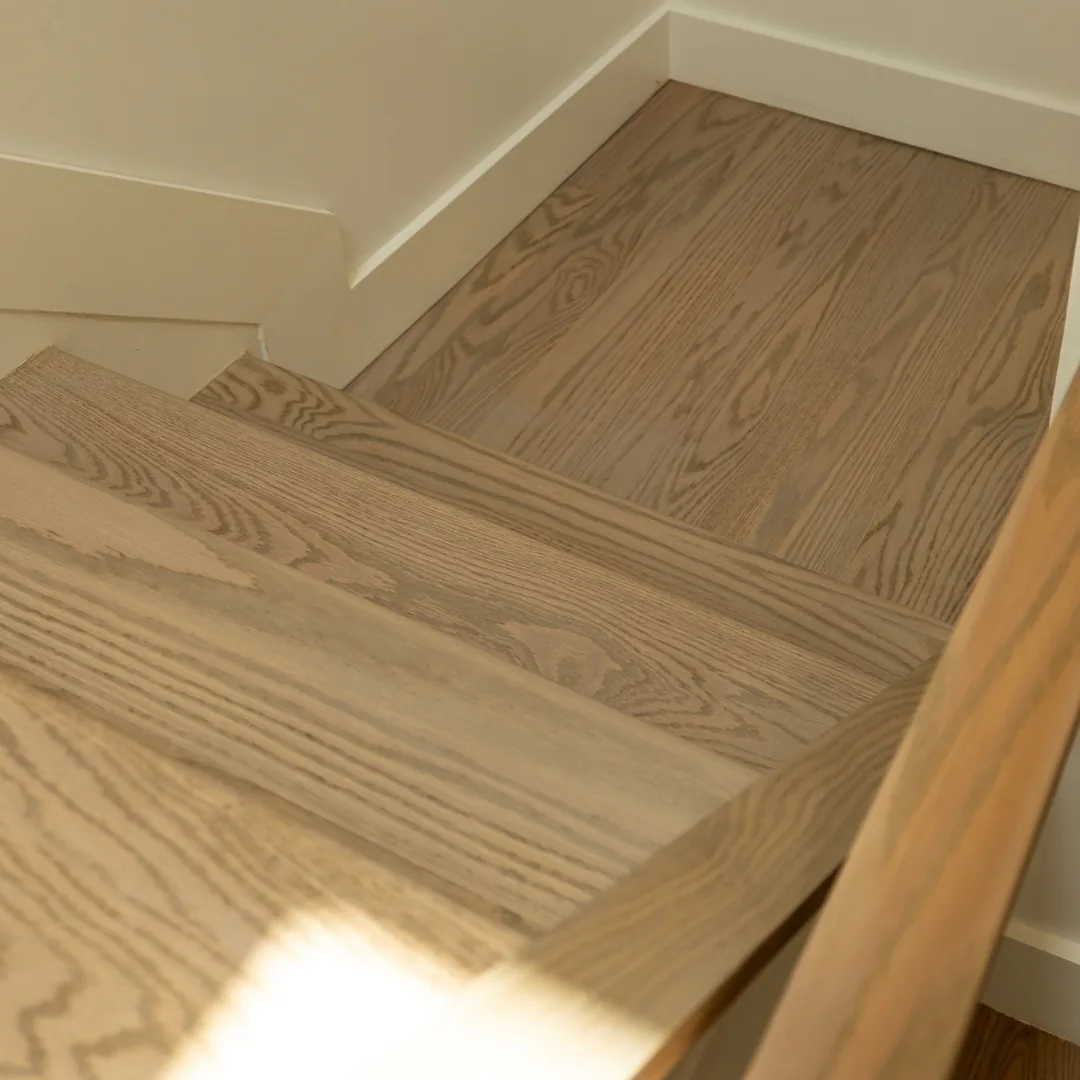 Beautiful wood staircase with white trim.