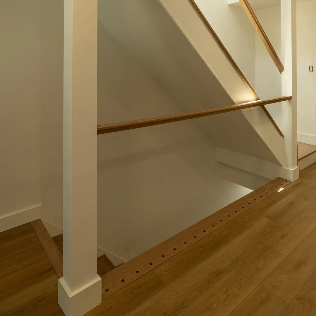 Modern staircase with wood handrails and floor.