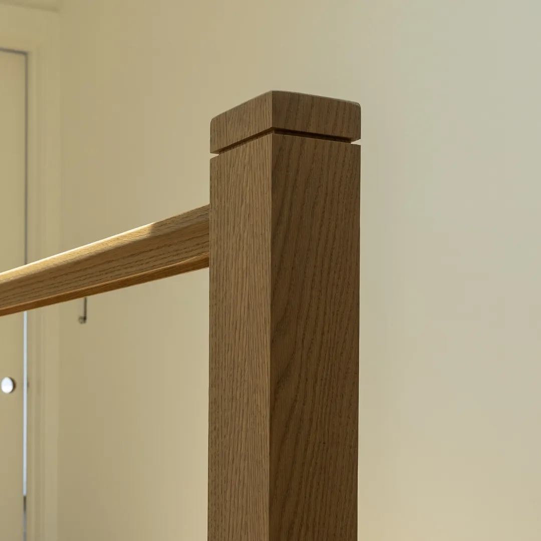 Close-up of wooden staircase newel post and railing