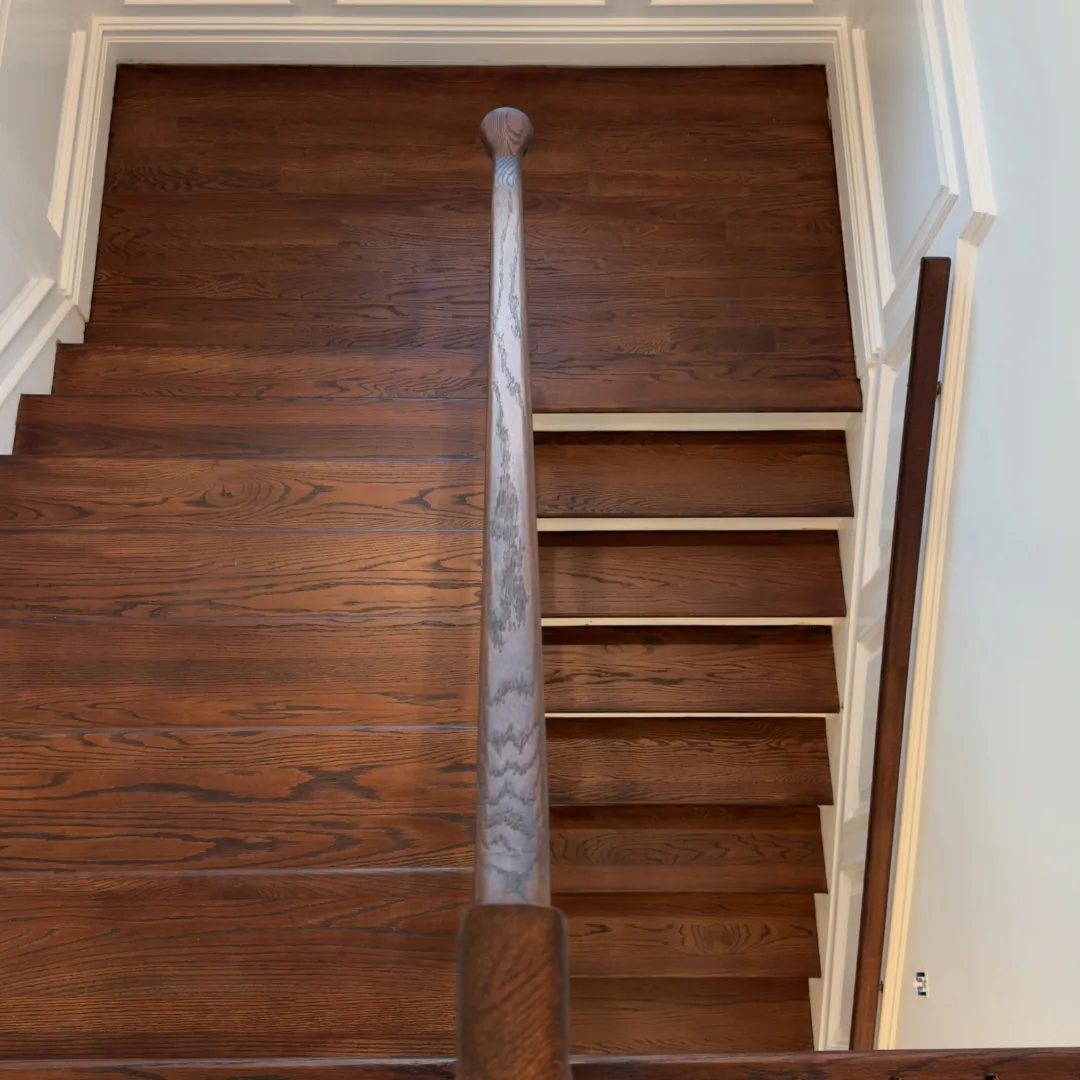 Dark wood staircase with white risers.