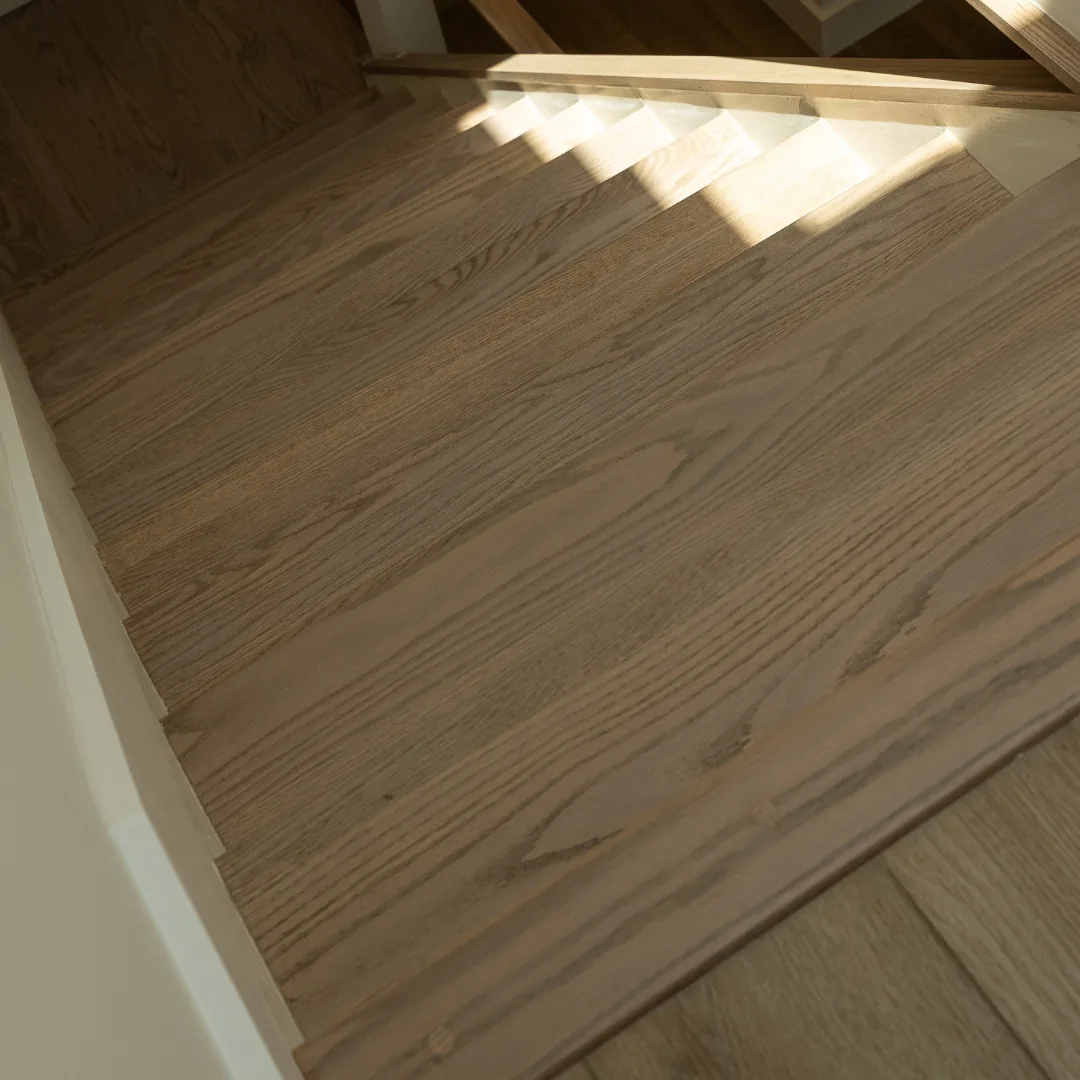 Newly refinished hardwood staircase with natural light.