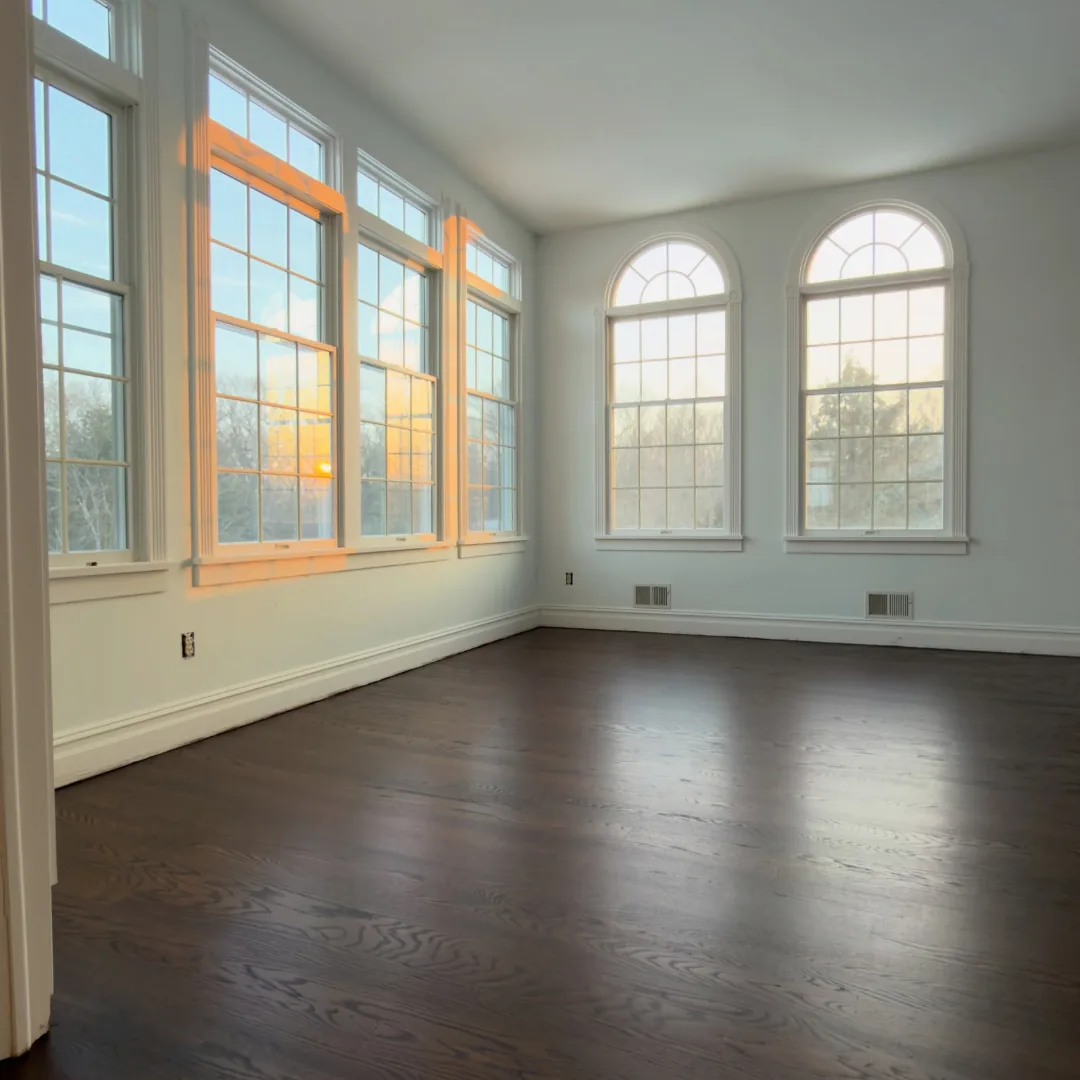 Newly installed dark hardwood floors in sunroom