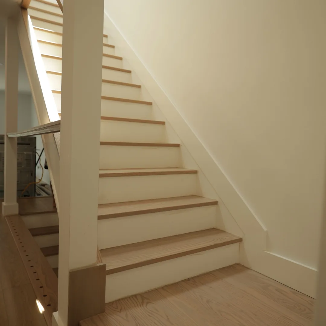 Newly installed hardwood staircase treads and risers.